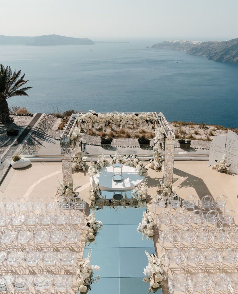 The wedding ceremony boasts a mirror aisle reflecting light, leading to a mirror gazebo adorned with white floral decorations. It's a stunning backdrop for the couple's vows, making the event truly memorable.