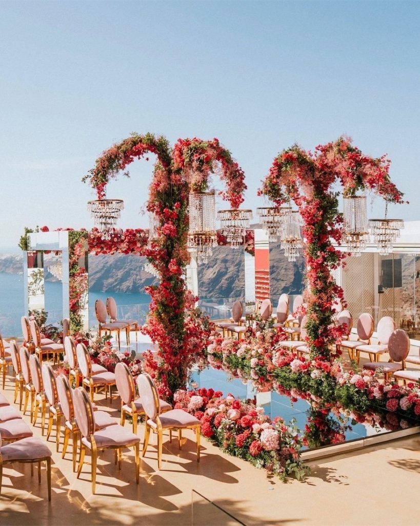 The wedding ceremony boasts a mirror aisle reflecting light, leading to a mirror gazebo adorned with red floral decorations.